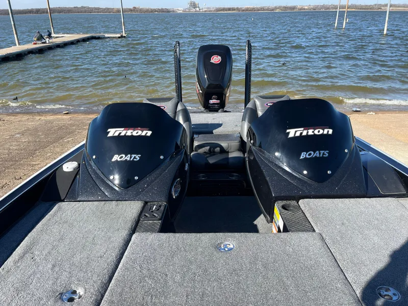 Slide: The Image of 2013 Triton 21 HP boat on a lake, featuring dual engines and spacious deck. - 38