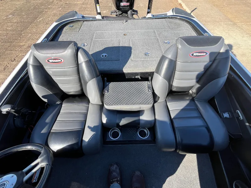 Slide: The Image of 2013 Triton 21 HP boat interior with dual black seats and cup holders. - 40