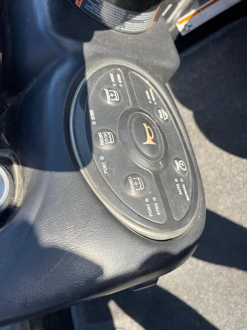 Slide: The Image of Control panel of a 2013 Triton 21 HP boat with various function buttons. - 43