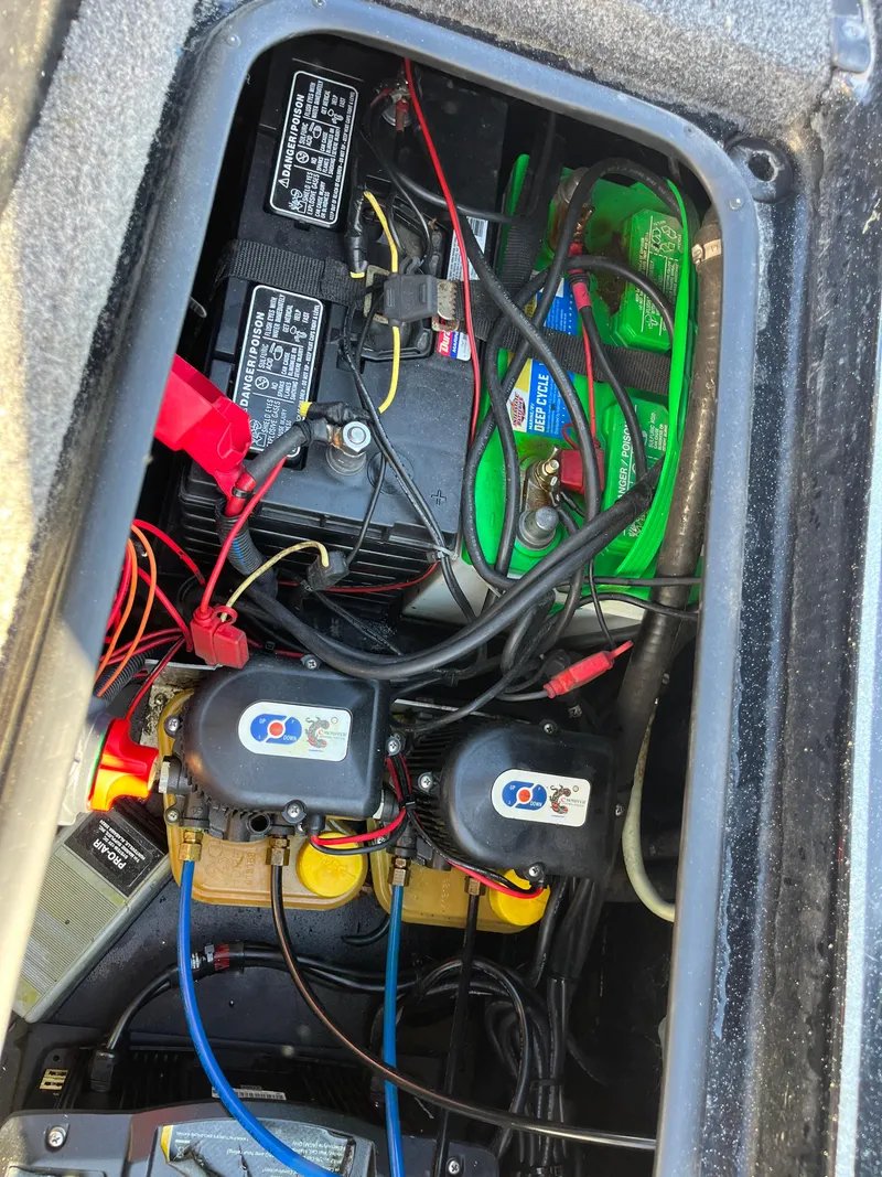 Slide: The Image of 2013 Triton 21 HP boat battery compartment with wiring and components. - 49