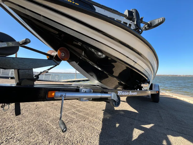 Slide: The Image of 2013 Triton 21 HP boat on trailer by the water. - 5