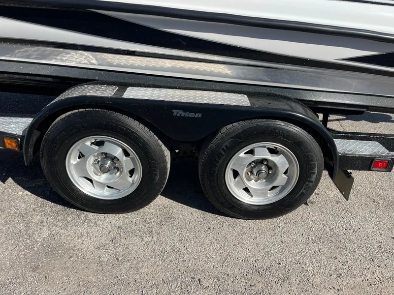Slide: The Image of 2013 Triton 21 HP trailer with dual wheels on asphalt. - 57