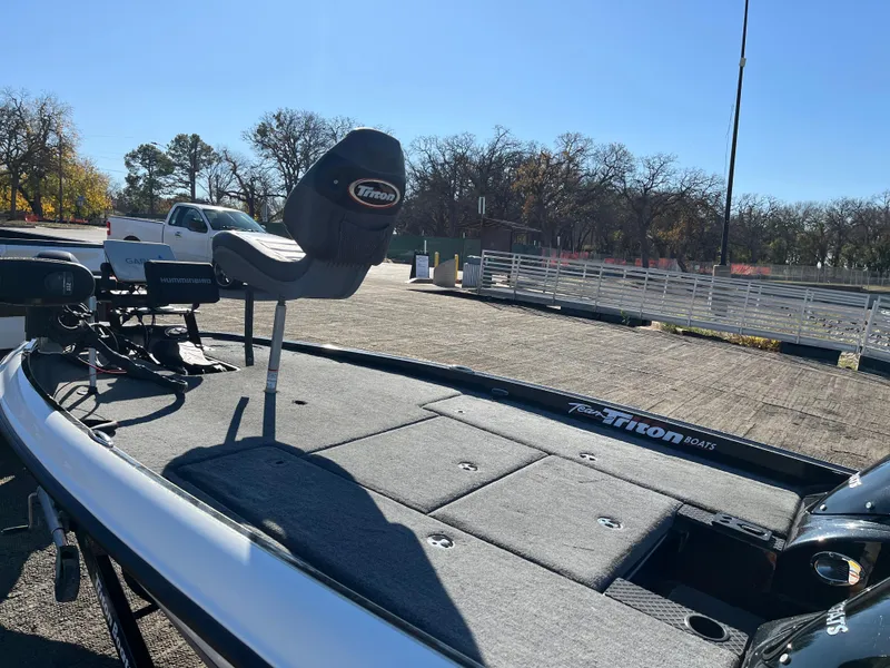 Slide: The Image of 2013 Triton 21 HP boat with seating, parked outdoors on a sunny day. - 7