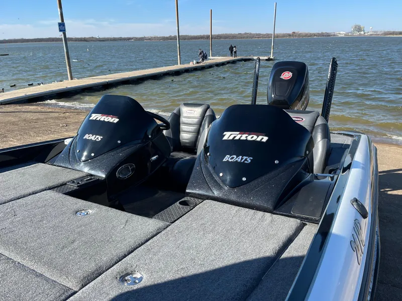 Slide: The Image of 2013 Triton 21 HP boat at lakeside dock under clear blue sky. - 8