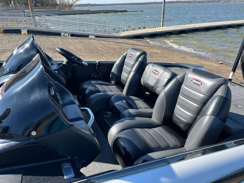 Slide: The Image of 2013 Triton 21 HP boat interior with black leather seats by the lake. - 9