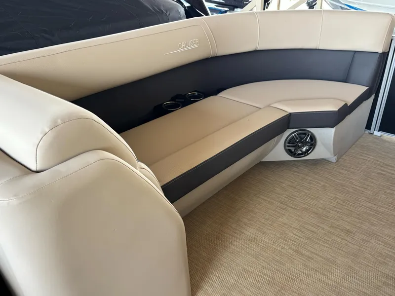 Slide: The Image of Luxurious seating on 2025 Harris CRUISER 230 SLDH boat, featuring beige upholstery and cup holders. - 2