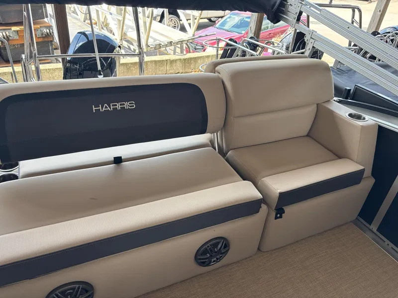Slide: The Image of 2025 Harris CRUISER 230 SLDH boat interior with beige seating and cup holder. - 3