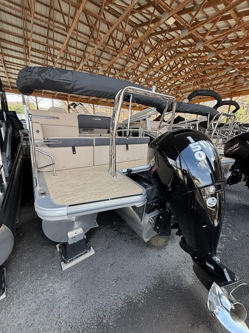 Slide: The Image of 2025 Harris CRUISER 230 SLDH pontoon boat with outboard motor, under a wooden canopy. - 6