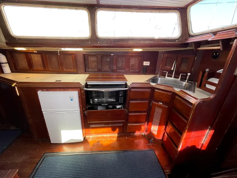 Slide: The Image of 1983 Islander Freeport yacht kitchen with wood cabinetry, sink, and appliances. - 11