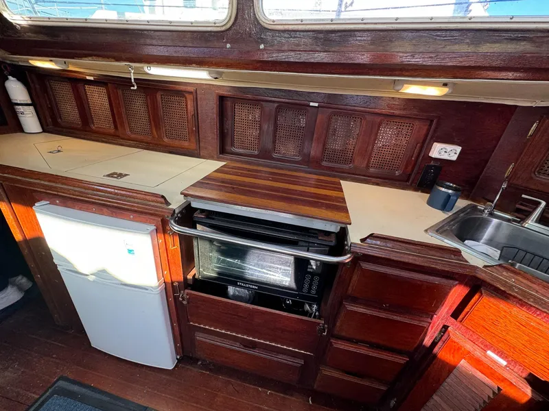 Slide: The Image of 1983 Islander Freeport yacht kitchen with wood cabinetry, stove, and sink. - 12