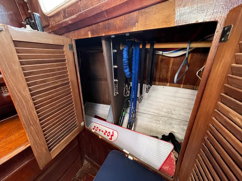 Slide: The Image of 1983 Islander Freeport sailboat interior storage with wooden cabinets and nautical equipment. - 24