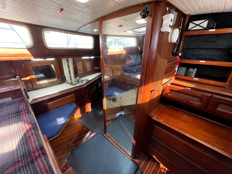 Slide: The Image of Interior of 1983 Islander Freeport sailboat with wood finish and cozy seating. - 25