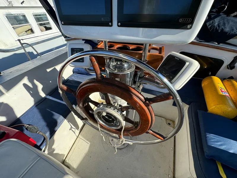 Slide: The Image of 1983 Islander Freeport yacht helm with wooden steering wheel and navigation equipment. - 36