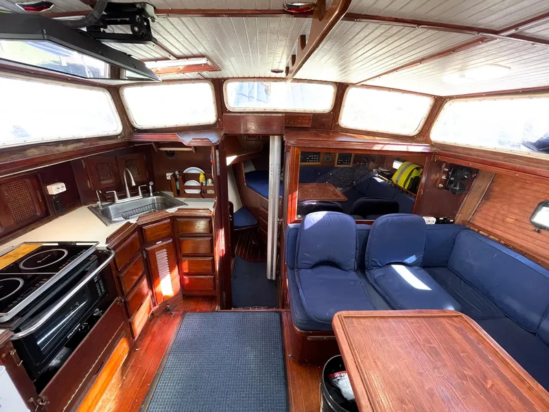 Slide: The Image of Interior of 1983 Islander Freeport sailboat with kitchen, seating, and wood finishes. - 4