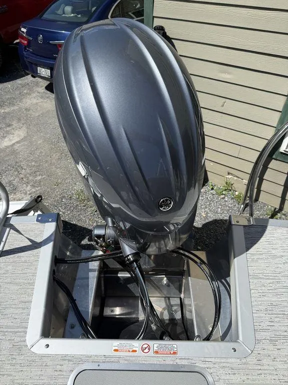 Slide: The Image of Outboard motor on a 2025 Bennington 22 MSB boat, parked near a building. - 10