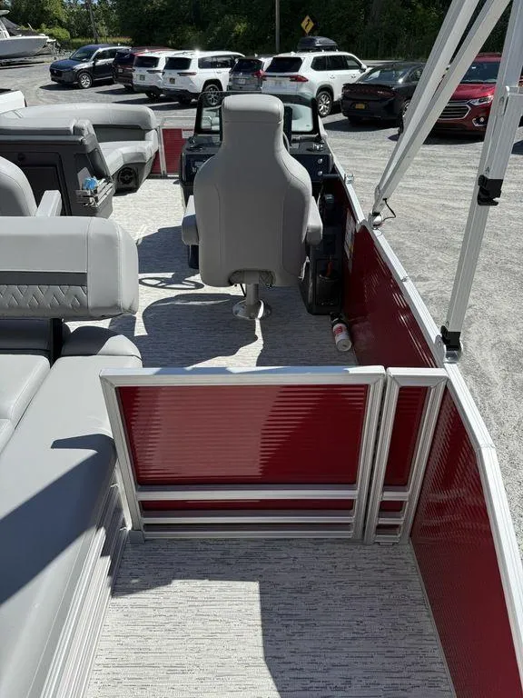 Slide: The Image of Interior of a 2025 Bennington 22 MSB pontoon boat with gray seating and red paneling. - 12
