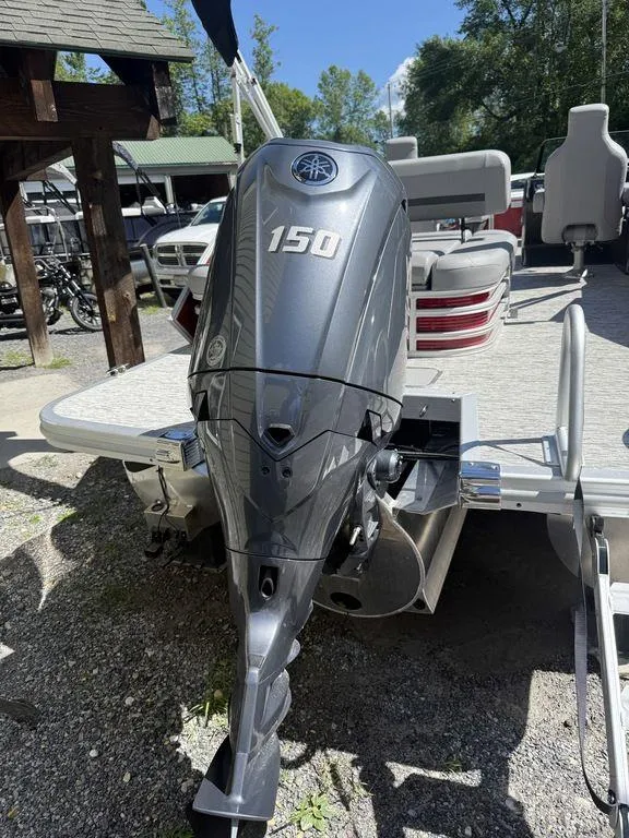 Slide: The Image of 2025 Bennington 22 MSB pontoon boat with Yamaha 150 outboard motor, docked outdoors. - 14