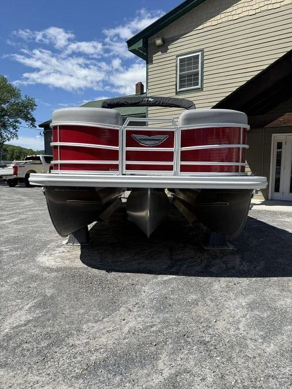 Slide: The Image of 2025 Bennington 22 MSB pontoon boat with red exterior, parked outdoors. - 2