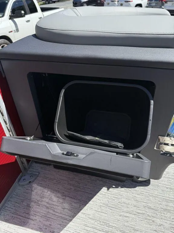 Slide: The Image of 2025 Bennington 22 MSB boat storage compartment with open lid, showing interior space. - 25