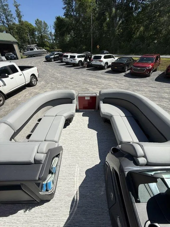 Slide: The Image of 2025 Bennington 22 MSB pontoon boat with spacious seating, parked outdoors. - 27