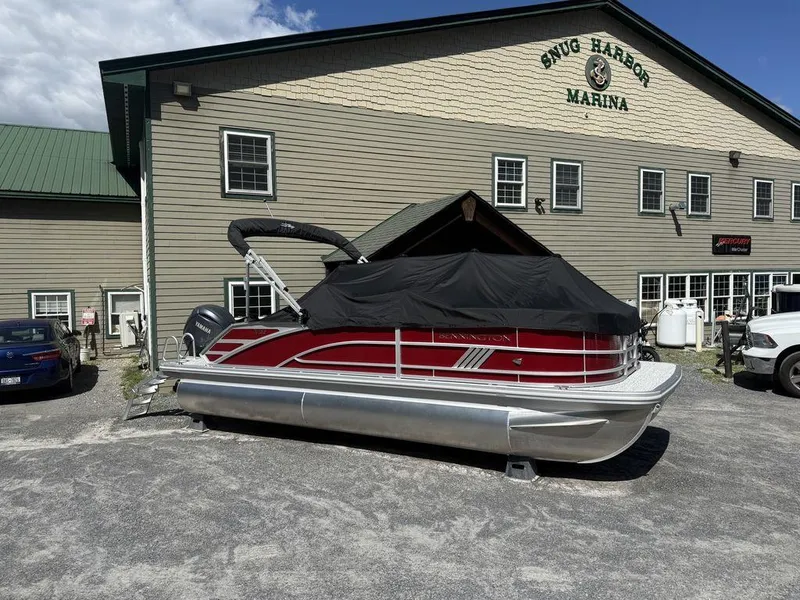 Slide: The Image of 2025 Bennington 22 MSB pontoon boat at Snug Harbor Marina, covered and parked outdoors. - 3