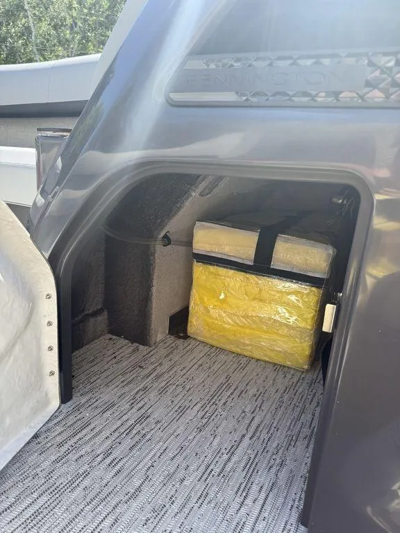 Slide: The Image of Storage compartment of 2025 Bennington 22 MSB boat with yellow bag inside. - 34