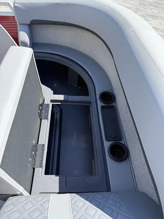 Slide: The Image of 2025 Bennington 22 MSB boat interior with open storage compartment and cup holders. - 38