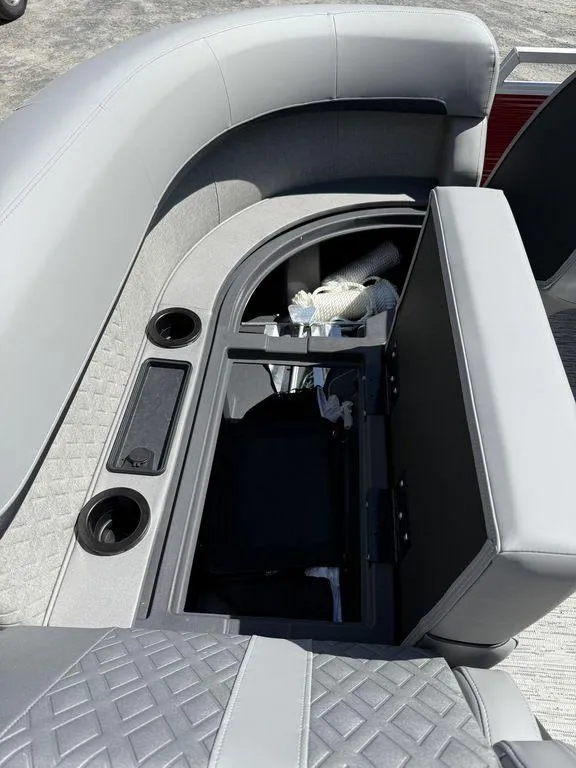 Slide: The Image of 2025 Bennington 22 MSB boat interior with open storage compartment and cup holders. - 40