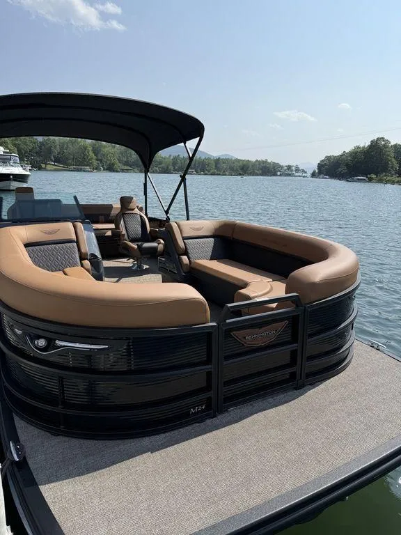 Slide: The Image of 2025 Bennington 24 MSB pontoon boat with luxurious seating on a serene lake. - 10