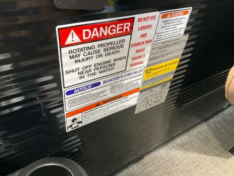 Slide: The Image of Safety warning labels on a 2025 Bennington 24 MSB boat, highlighting propeller danger. - 23