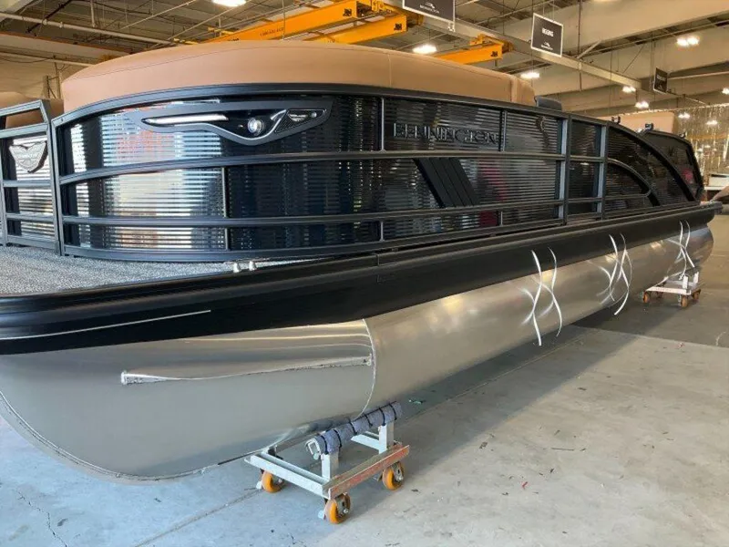 Slide: The Image of 2025 Bennington 24 MSB pontoon boat in a showroom, showcasing sleek design and modern features. - 24