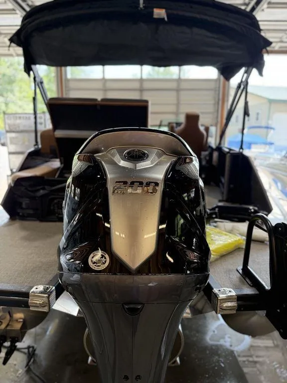 Slide: The Image of 2025 Bennington 24 MSB boat with powerful 200 HP engine in a garage setting. - 6