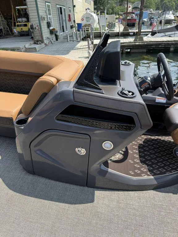 Slide: The Image of 2025 Bennington 24 MSB boat console with tan seating, docked at marina. - 9