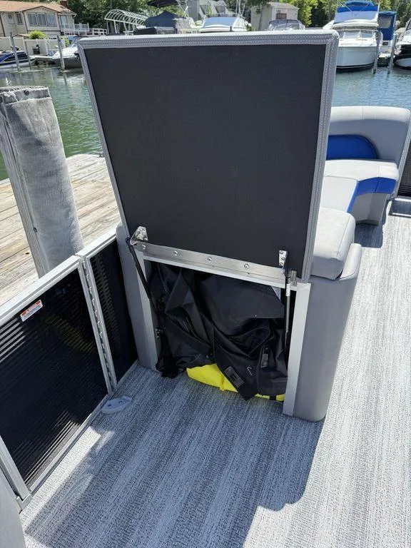 Slide: The Image of 2025 Bennington 25LSR boat interior with open storage compartment and seating area. - 16