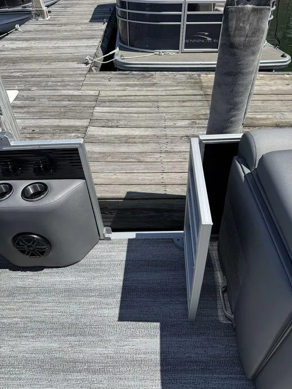 Slide: The Image of 2025 Bennington 25LSR pontoon boat interior with open side gate at dock. - 17
