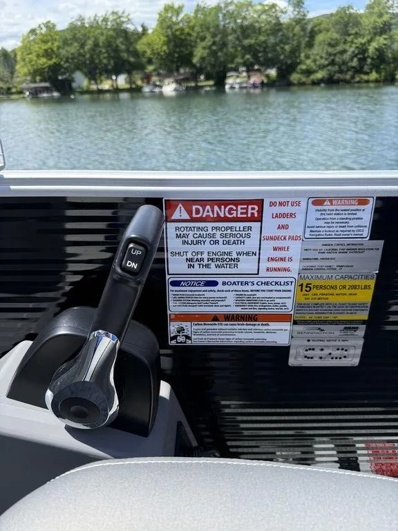 Slide: The Image of Throttle control and safety warnings on a 2025 Bennington 25LSR boat, with lake view. - 20