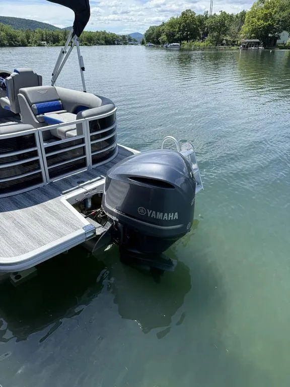 Slide: The Image of 2025 Bennington 25LSR pontoon boat with Yamaha outboard motor on a serene lake. - 4