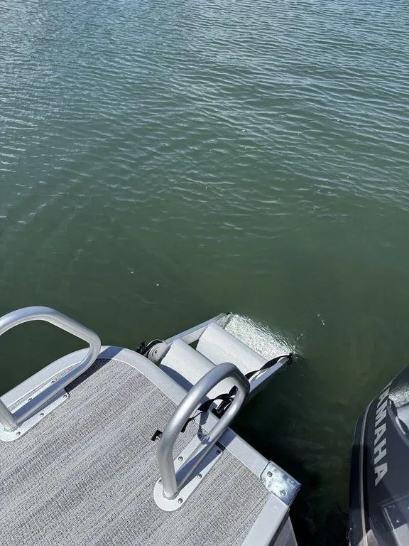 Slide: The Image of 2025 Bennington 25LSR boat deck with ladder and Yamaha motor on water. - 5