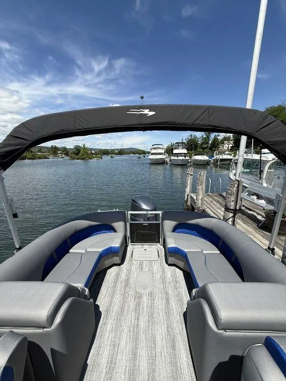 Slide: The Image of 2025 Bennington 25LSR pontoon boat docked on a sunny day, featuring spacious seating and canopy. - 6