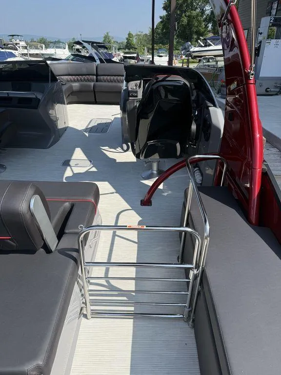 Slide: The Image of 2025 Bennington 25RSBWAX1 pontoon boat interior with seating and helm, docked at marina. - 11
