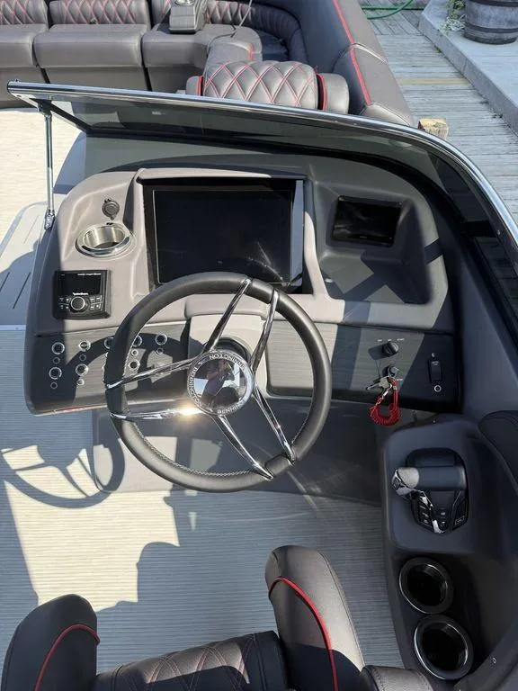 Slide: The Image of 2025 Bennington 25RSBWAX1 boat dashboard with steering wheel and control panel. - 18