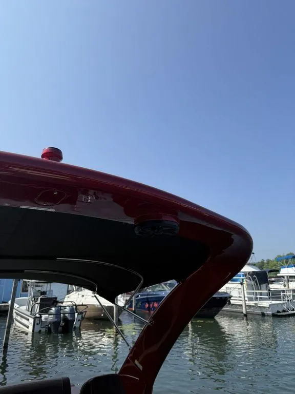 Slide: The Image of 2025 Bennington 25RSBWAX1 boat docked at marina under clear blue sky. - 22