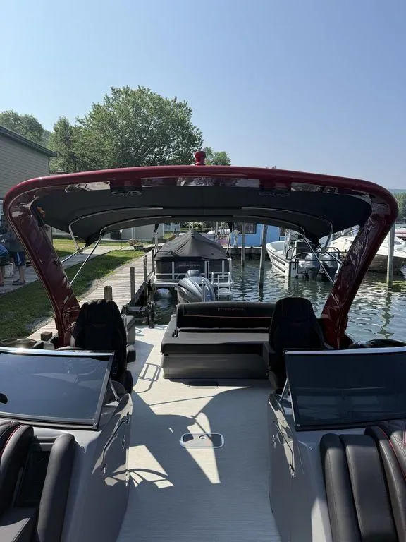 Slide: The Image of 2025 Bennington 25RSBWAX1 boat docked at a marina under clear blue skies. - 23