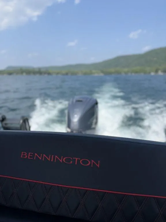 Slide: The Image of 2025 Bennington 25RSBWAX1 boat cruising on a lake with scenic mountain views. - 3