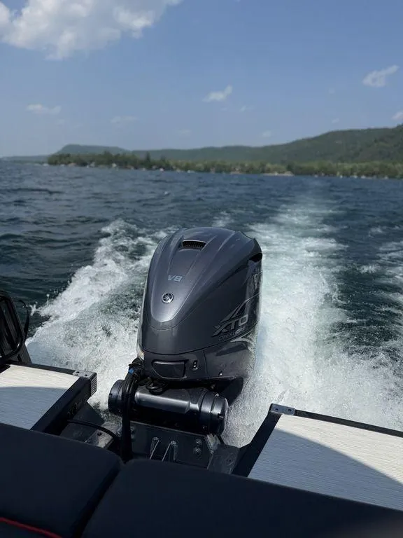 Slide: The Image of 2025 Bennington 25RSBWAX1 boat with powerful outboard motor on a scenic lake. - 5