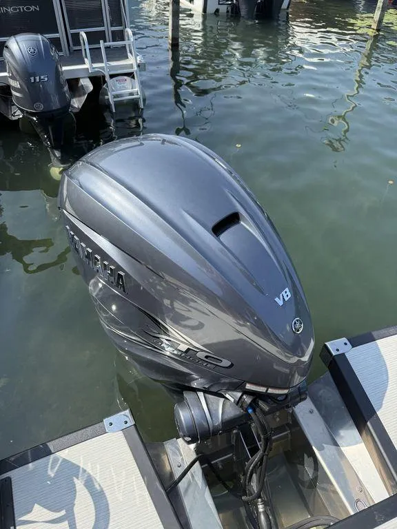 Slide: The Image of Outboard motor on a 2025 Bennington 25RSBWAX1 boat, docked in calm water. - 6