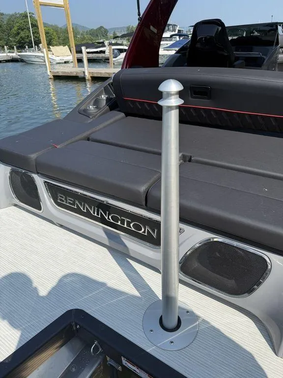 Slide: The Image of 2025 Bennington 25RSBWAX1 boat interior with seating and pole, docked by the water. - 9