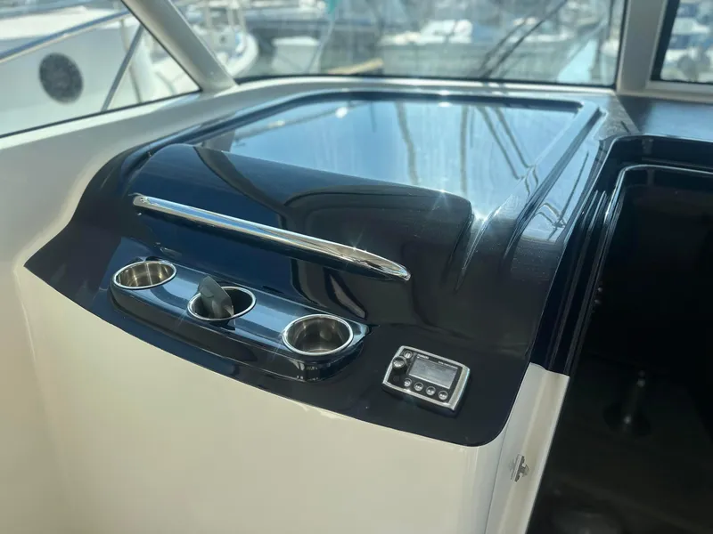 Slide: The Image of 2016 Tiara Yachts 3100 Coronet dashboard with sleek black finish and controls. - 14
