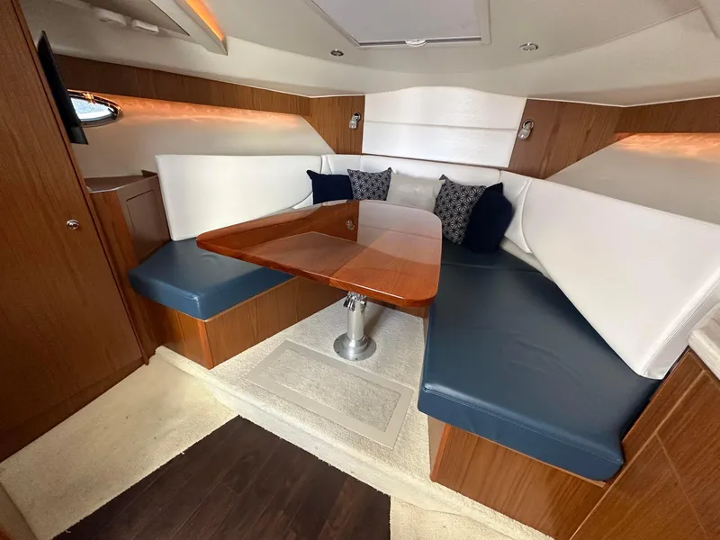 Slide: The Image of 2016 Tiara Yachts 3100 Coronet interior with elegant seating and wooden table. - 15