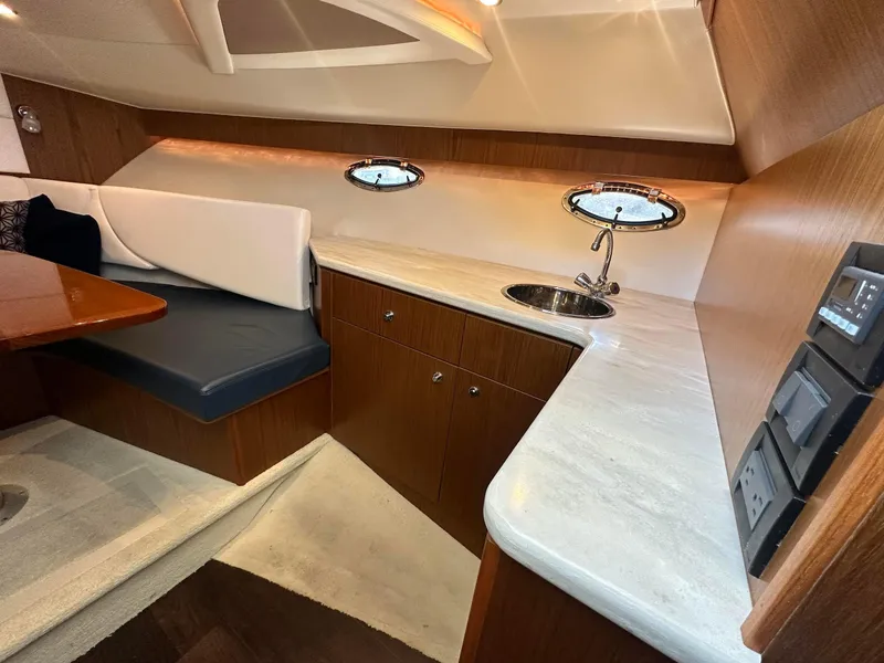 Slide: The Image of 2016 Tiara Yachts 3100 Coronet interior with kitchenette and seating area. - 18